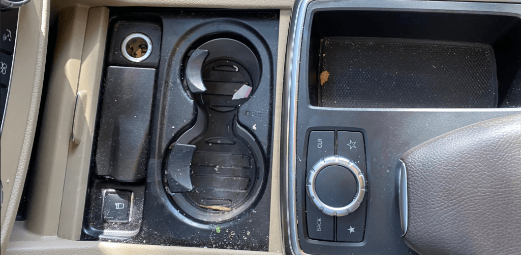 Heavily soiled centre console and cup holders before detailing