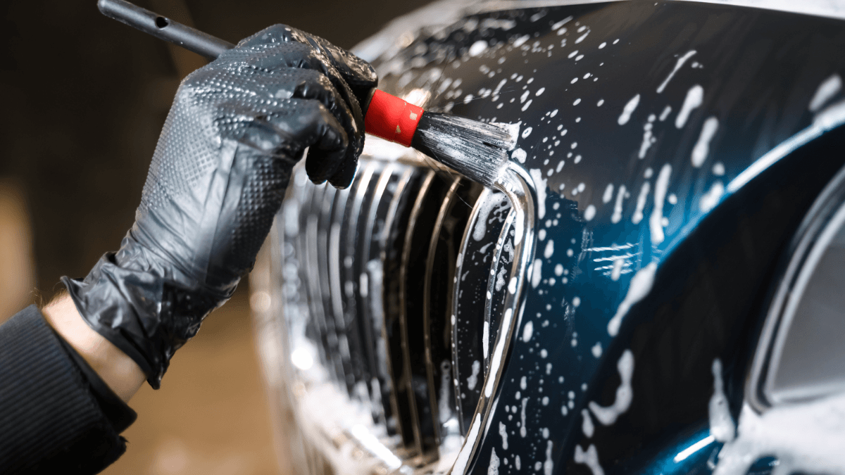 Tanner detailing a chrome grille with a professional brush, Phantom Car Detailing
