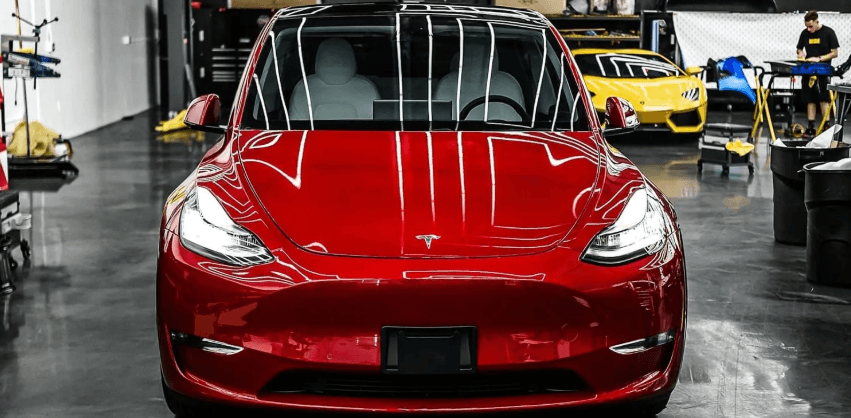 Red Tesla Model 3 freshly detailed in a professional detail studio